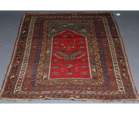 A TURKISH PRAYER RUG, the green field with stepped red niche with flowers and candles, within a multi guard surround in yello