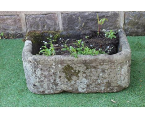 A SANDSTONE TROUGH of rough hewn D form, 25" x 15" x 10 1/2" (Est. plus 24% premium inc. VAT)Very good