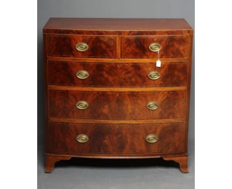 A REGENCY MAHOGANY BOW FRONT CHEST, c.1800, with boxwood stringing, the caddy top over two short and three long drawers with 