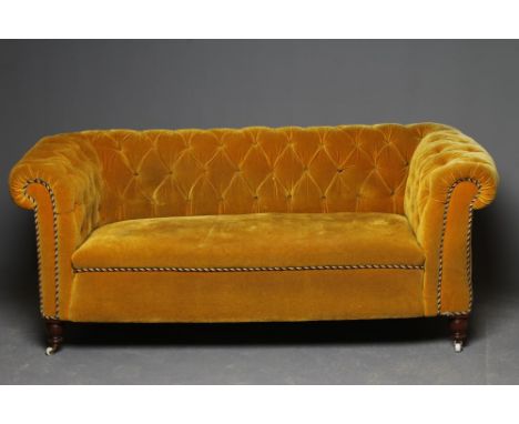 A VICTORIAN WALNUT FRAMED CHESTERFIELD DROP END SETTEE button upholstered in mustard yellow velvet, on turned tapering feet w