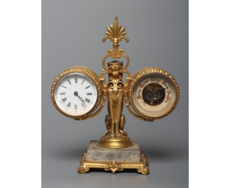 A GILT METAL FIGURAL DESK COMPENDIUM, c.1900, comprising a clock and barometer suspended from a scrolled bracket with central