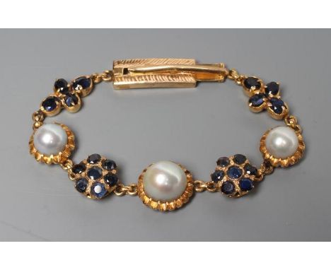 A SAPPHIRE AND PEARL BRACELET, the three graduated grey pearls set in frilled mounts between a pair of sapphire clusters and 