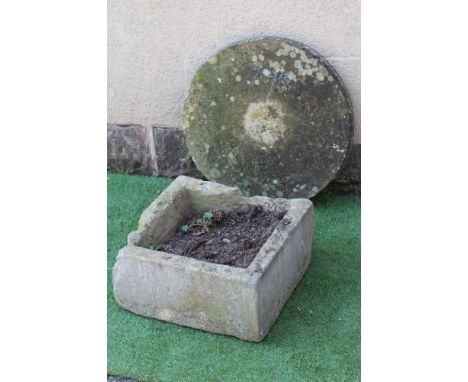 A SANDSTONE MILL WHEEL, 23 1/2" high, together with a square sandstone trough, 18" x 18" x 9" (2) (Est. plus 24% premium inc.