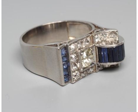 AN ART DECO STYLE SAPPHIRE AND DIAMOND "BUCKLE" COCKTAIL RING, the central diamond of approximately 0.5cts to a pave set diam