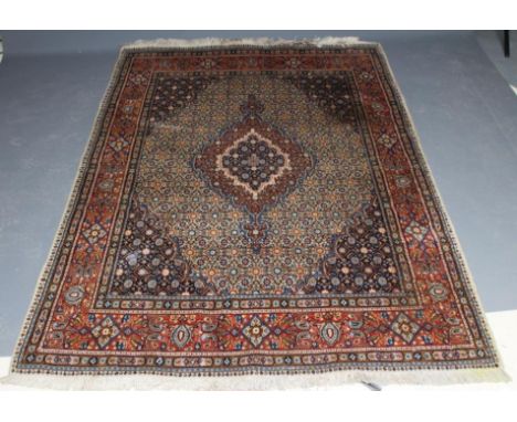 A PERSIAN RUG, the ivory floral field with central gul in red, ivory and navy blue, conforming spandrels and red main border,