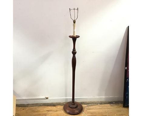 A wooden floor lamp, the fluted baluster stem incorporating a foliate knop raised on a gadrooned base (h.158cm to top of ligh