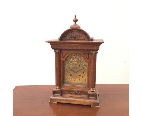 A German quarter chiming Ting-Tang mantel clock, the arched brass dial with arabic numerals, within an architectural case inc