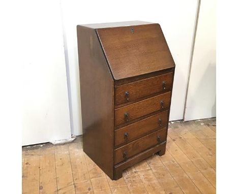A 1920s small bureau, the rectangular fall front enclosing pigeonholes and a writing surface, above four drawers, raised on b