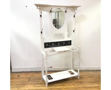 An Art Nouveau and later white painted hall stand, the rectangular back incorporating a shield shaped mirror and an arrangeme