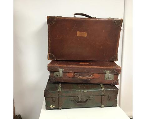 A group of vintage travelling cases including two in brown leather, the third in canvas with a chocolate brown painted exteri