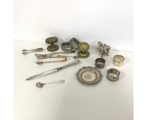 A collection of three silver napkin rings along with a small silver dish with a C scroll edge, a silver condiment pot (combin