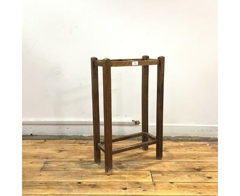 An early 20thc oak stick stand, the square section supports enclosing a two division rest, with square section stretchers bel