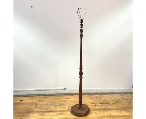 A 1940s turned wood floor lamp, the baluster stem incorporating acanthus carving, raised on a dished base with flattened bun 