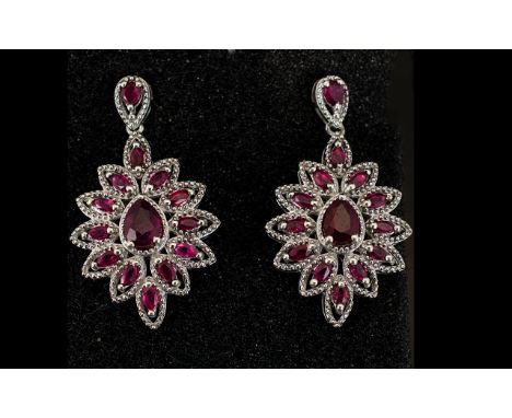 Ruby Ovoid Cluster Drop Earrings, each earring having a pear cut ruby surrounded by marquise cut rubies in a milgrain platinu