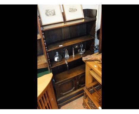 An oak three shelf bookcase with cupboard under - width 65cms
