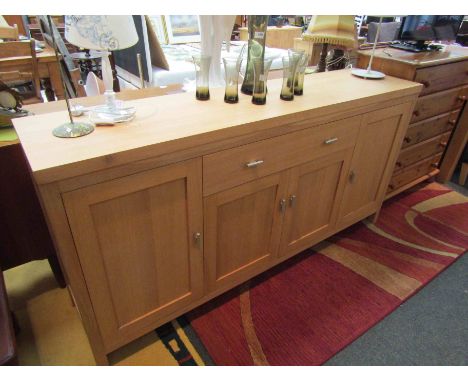 A modern light oak sideboard with central drawer and cupboard doors, 181cm wide x 89cm high x 43cm deep