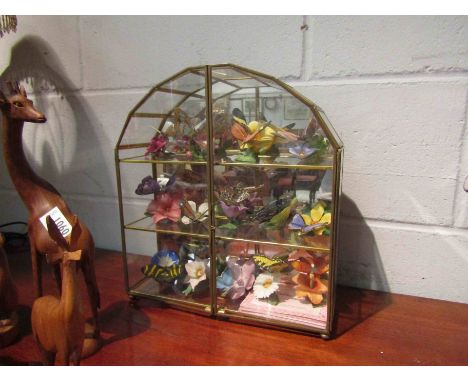 A brass framed display glass case containing a collection of ceramic butterflies, case a/f
