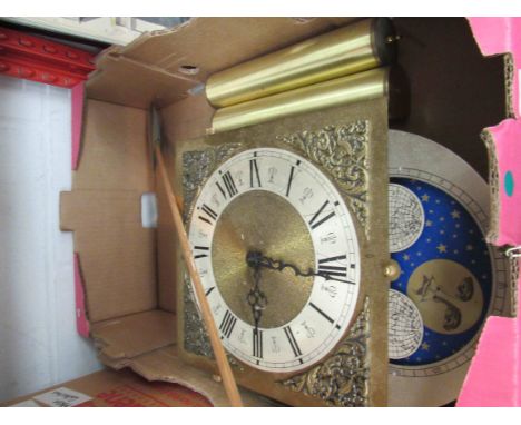 A brass clock face with mechanism and weights, pendulum, etc