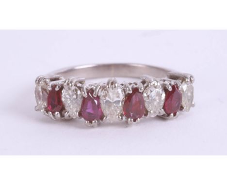 An 18ct white gold ruby and diamond ring, the nine stones of pear shape, size M.