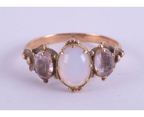 An antique three stone ring, set with an opal in unmarked yellow gold, size K/L.