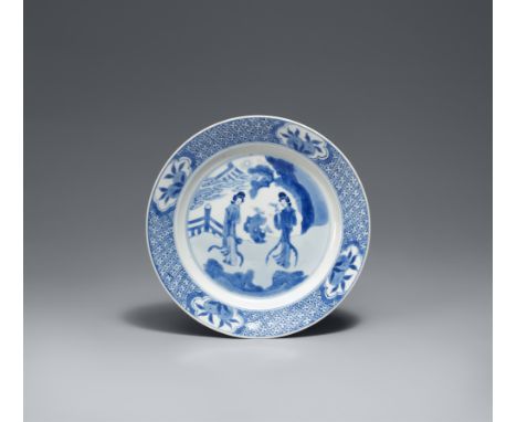 Kleiner blau-weißer Teller. Kangxi-Ära (1662-1722)Im Spiegel zwei Damen in einem Garten. Auf der Fahne eine Windelbordüre mit