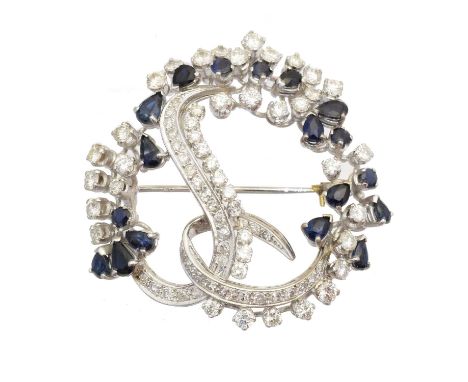 A sapphire and diamond brooch, of asymmetric design, the pear and circular shape sapphires within a vari cut diamond surround