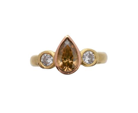 A 'brown' diamond and diamond three stone ring, the pear shape 'brown' diamond with brilliant-cut diamond sides, estimated to