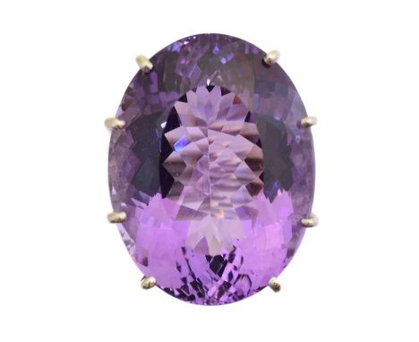 A 9ct gold amethyst and diamond dress ring, the oval shape amethyst weighing approx. 25.5cts within a single cut diamond set 