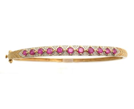 A ruby and diamond hinged bangle, the circular shape ruby line with single cut diamond spacers and plain hinged reverse, stam