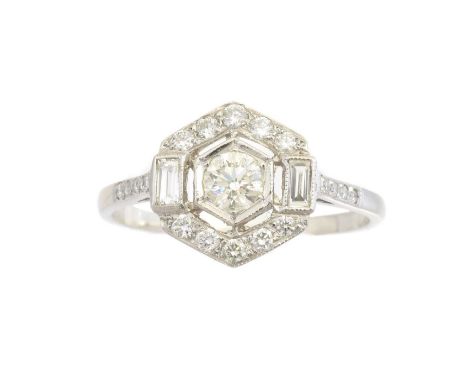 A diamond cluster ring, of geometric design, the circular cut diamond within a vari cut diamond hexagonal surround and brilli