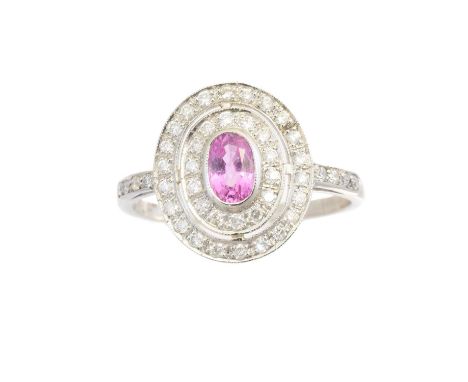 A sapphire and diamond cluster ring, the oval shape pink sapphire within a brilliant cut diamond double surround and similarl