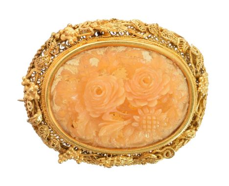 An early 20th century horn brooch, the oval horn carving depicting a floral thicket in high relief, within a wirework surroun