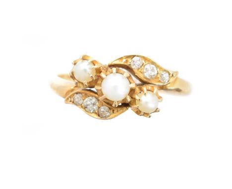 An early 20th century 18ct gold pearl and diamond dress ring, the pearl trio with old cut diamond crossover shoulders, hallma