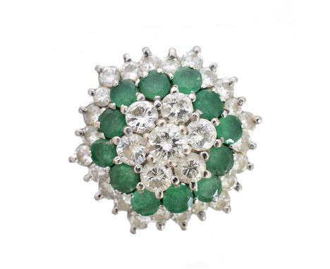 An emerald and diamond cluster ring, the brilliant cut diamond cluster within a circular shape emerald and brilliant cut diam