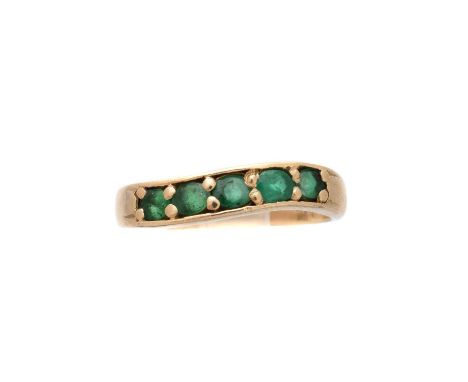 An emerald band ring, designed as an undulating oval shape emerald line, stamped 14k, ring size L, gross weight 2.5g.Conditio