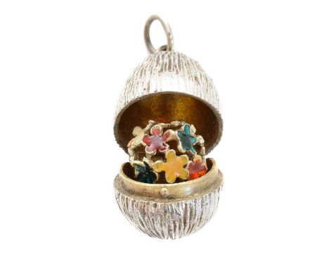 A silver and enamel egg pendant by Stuart Devlin, the textured egg opening to reveal a silver gilt interior and vari-shade en