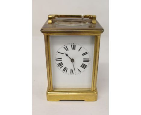 Early 20th century carriage clock with French eight day movement and lever escapement striking on a gong, white enamel dial w