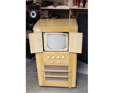 1940s black and white console television in a bleached walnut case with twin-opening doors, 98cm overall height