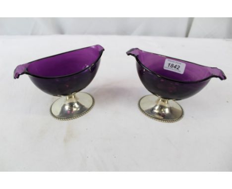 Pair of silver and amethyst glass bonbon dishes, the boat-shaped glass on oval pedestal bases with gadrooned borders, retaile