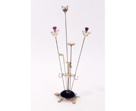 Four various silver hat pins and one other gilt metal hat pin within a novelty silver pin cushion holder in the form of a tor