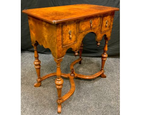 A reproduction walnut lowboy, rectangular top above one short and two deep cockbeaded drawers, turned legs, curved X-stretche