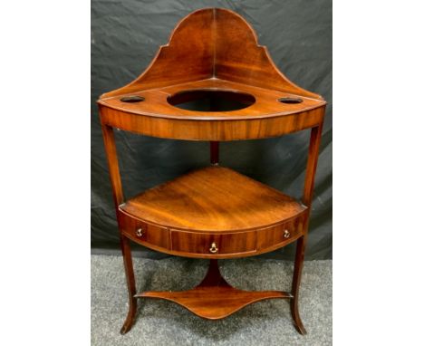 A George III mahogany, bow-front, corner wash stand, arched backsplash, three tiers with small drawer, and two small faux dra