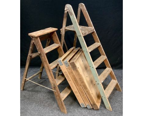 A Set of early 20th century pine, four rung, step ladders; another set, smaller; and three large pine trays, (5). 