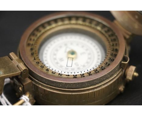 A brass compass stamped TG CO LTD 1943 with a crows foot mark 