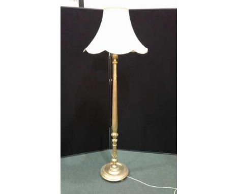 Gilt standard lamp with reeded acanthus leaf decorated stem and shade.