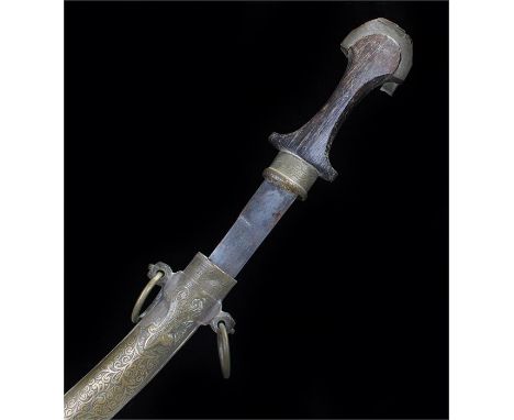 Jambiya type knife, with a carved handle and brass swag decorated scabbard, steel balde