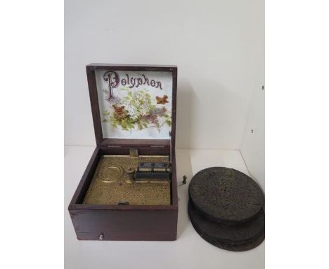 A mahogany cased polyphon with 12 16.5cm discs, in working order all teeth present, 3 discs are damaged, case measures 13cm t