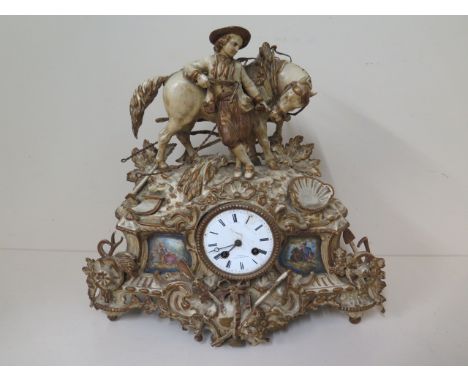 A French painted spelter figural mantle clock with porcelain plaques, 39cm tall x 42cm wide, for restoration 