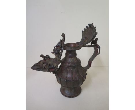 An Eastern metal oil lamp with red and gilt patinated finish, 30cm tall x 27cm long 