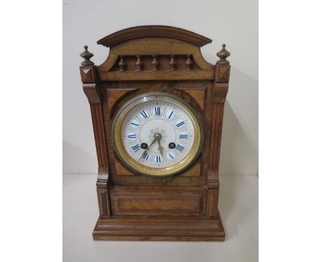 A walnut 8 day French mantle clock with ceramic dial, striking on a bell, 29cm tall, in good condition 